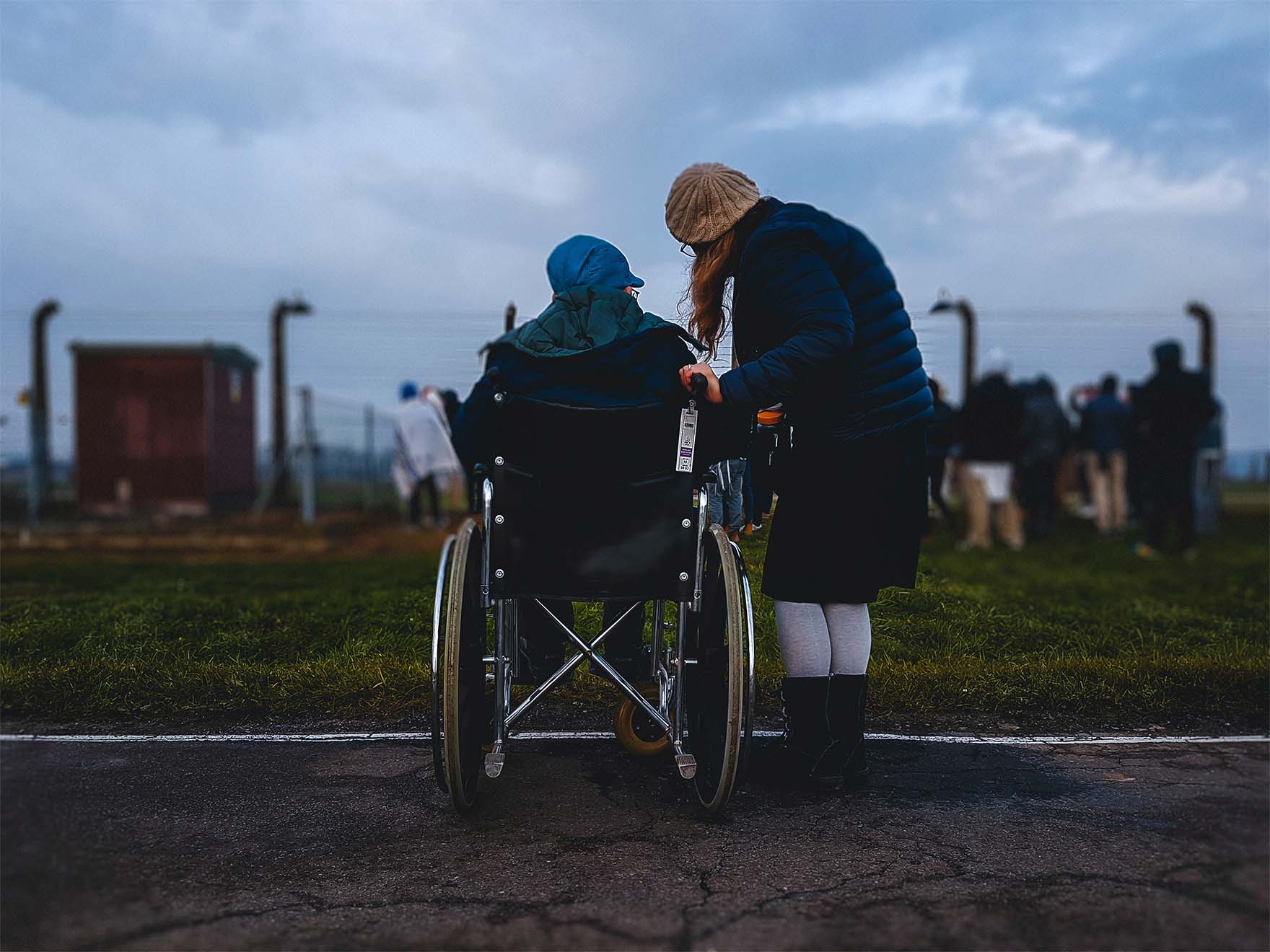 person in wheelchair outdoors with carer