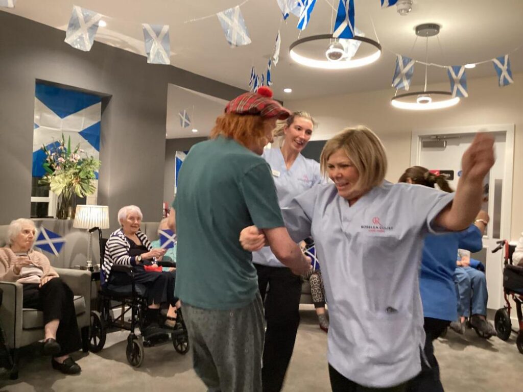 resident dancing with carer in lounge