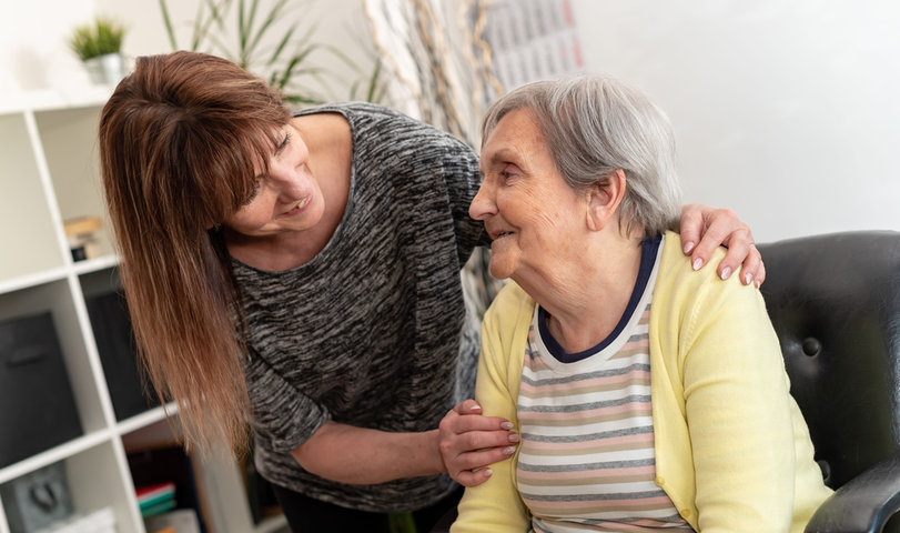 old woman getting visit from her daughter in a care home