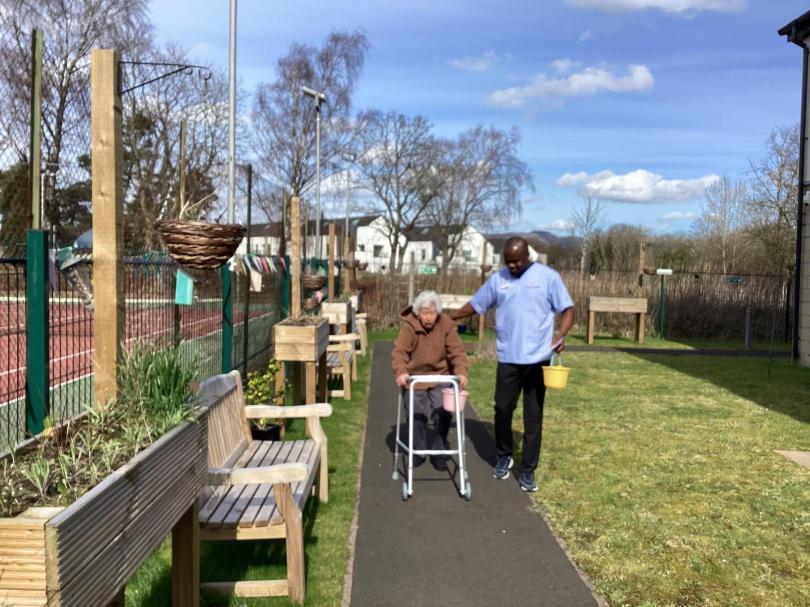 resident with a basket and a walker on her easter hunt in their garden